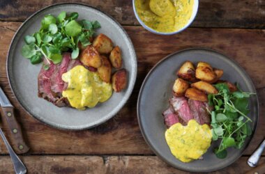 Cote de boeuf cooked rare and covered in a béarnaise sauce, served alongside potatoes and watercress.