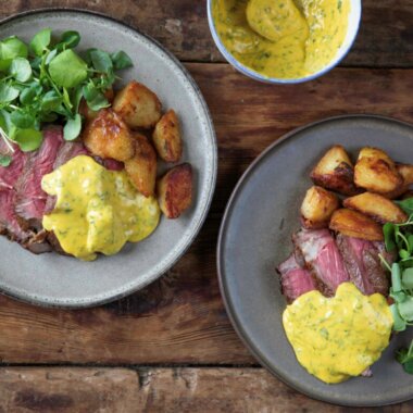 Cote de boeuf cooked rare and covered in a béarnaise sauce, served alongside potatoes and watercress.