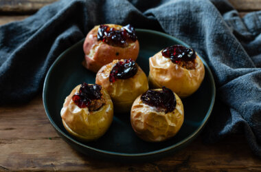 Five roasted Christmas apples filled with sausage and topped with jelly.