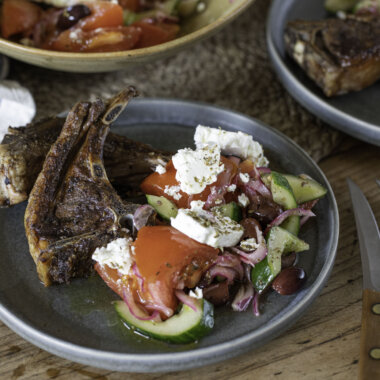 Close-up of Greek salad, plated with hogget chops.