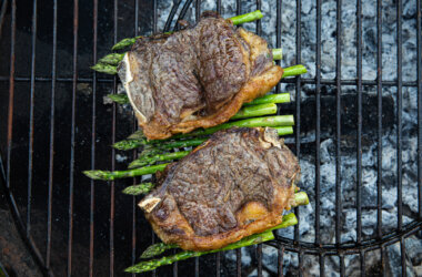 Sirloin steak and asparagus spears on a barbeque grill