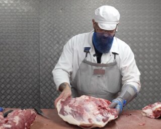 The mighty Topside comes from the inside of the hind leg. It has a finer grain than the silverside beside it, it’s softer, and it needs less time in the oven. Our butcher Trevor takes it off the top of beef, trims out the vein that runs through its centre, and does one more thing before he ties it, because a joint this lean rarely arrives with enough fat of its own.