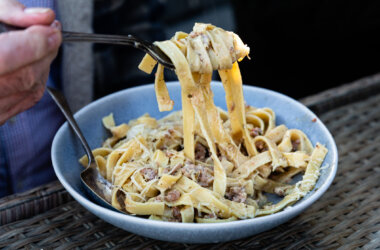 Bowl of fennel sausage ragù served over pasta, topped with grated Parmesan