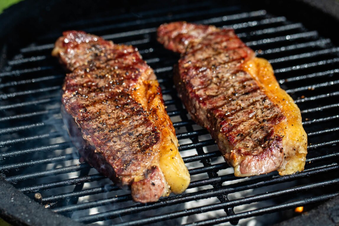 2 Swaledale Sirloin Steaks grilling on a charcoal BBQ