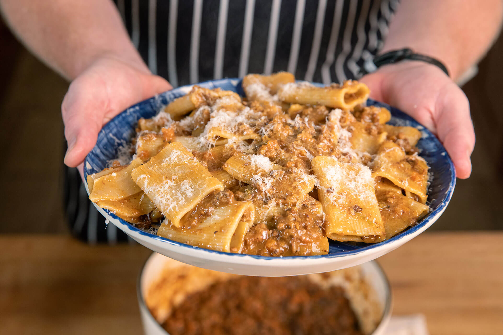 Plate of pasta topped with slow-cooked bolognese sauce (ragù alla bolognese) and grated Parmesan