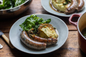 Wild Garlic Sausages with Champ Mash, Spring Greens & Onion Gravy