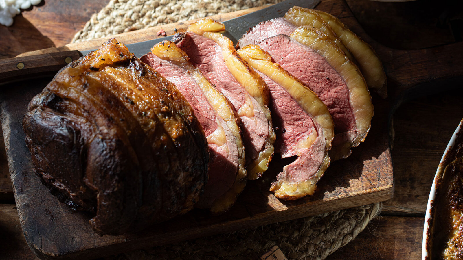 A slide Swaledale Beef Rump on a wooden chopping board